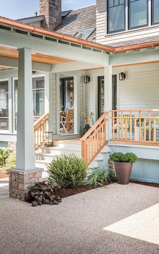 A light blue home with a front deck.